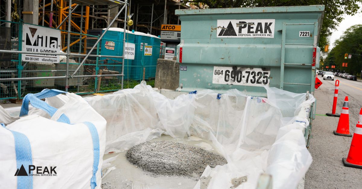 Construction dumpster and white bags filled with debris at a job site, commonly accepted materials for rental disposal
